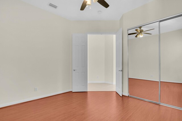 8851 Oldham Way, Palm Beach Gardens, FL 33412 - unfurnished bedroom with wood finished floors, ceiling fan, and a closet