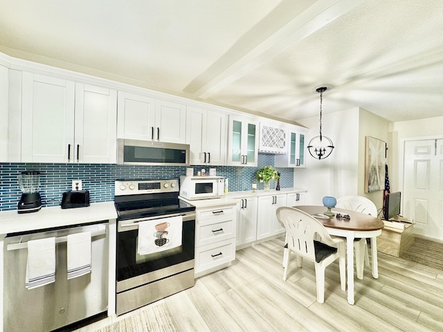 312 Knotty Pine Cir Unit C-1, Greenacres, FL 33463 - kitchen featuring appliances with stainless steel finishes, decorative backsplash, light countertops, a chandelier, and light wood-style floors