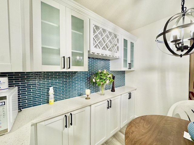 312 Knotty Pine Cir Unit C-1, Greenacres, FL 33463 - kitchen with backsplash, a chandelier, white cabinets, and light stone countertops