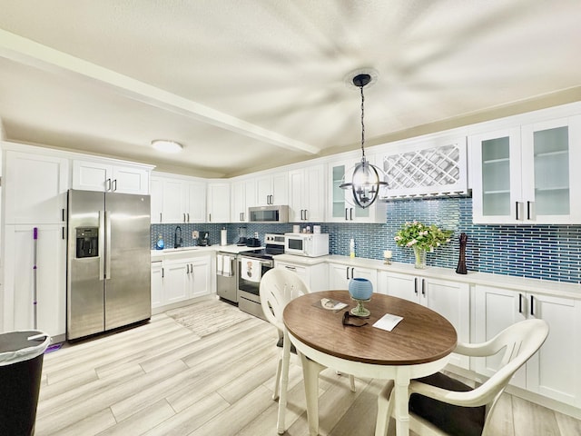 312 Knotty Pine Cir Unit C-1, Greenacres, FL 33463 - kitchen featuring appliances with stainless steel finishes, tasteful backsplash, light countertops, white cabinets, and glass insert cabinets