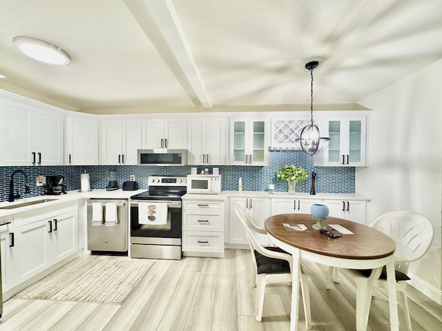 312 Knotty Pine Cir Unit C-1, Greenacres, FL 33463 - kitchen with stainless steel appliances, decorative backsplash, light wood-type flooring, light countertops, and white cabinetry