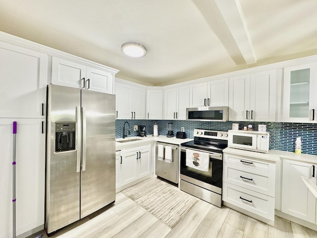 312 Knotty Pine Cir Unit C-1, Greenacres, FL 33463 - kitchen featuring stainless steel appliances, tasteful backsplash, light countertops, white cabinetry, and beam ceiling