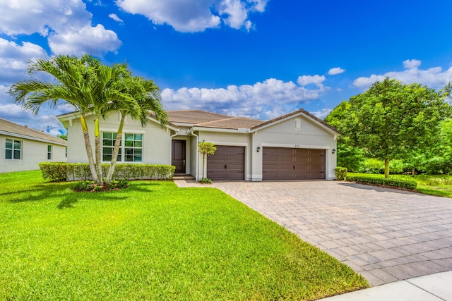 2571 SW Berry Park Cir, Palm City, FL 34990 - ranch-style home with a garage, decorative driveway, a front lawn, stucco siding, and a tile roof