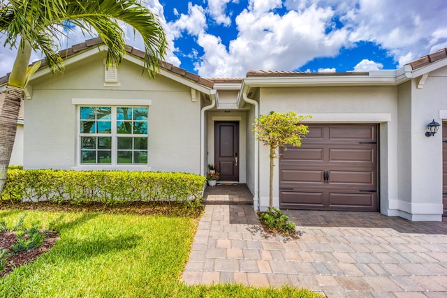2571 SW Berry Park Cir, Palm City, FL 34990 - view of front of house with stucco siding, an attached garage, a tile roof, and driveway