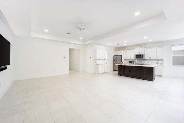 2571 SW Berry Park Cir, Palm City, FL 34990 - kitchen featuring stainless steel appliances, a tray ceiling, open floor plan, decorative backsplash, and recessed lighting