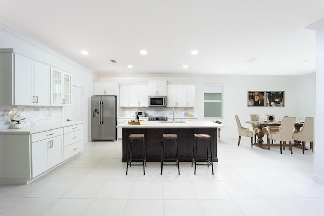 2571 SW Berry Park Cir, Palm City, FL 34990 - kitchen with appliances with stainless steel finishes, tasteful backsplash, a kitchen breakfast bar, crown molding, and light countertops