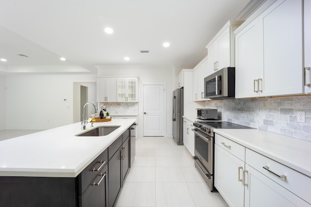 2571 SW Berry Park Cir, Palm City, FL 34990 - kitchen with stainless steel appliances, white cabinets, tasteful backsplash, light countertops, and a center island with sink