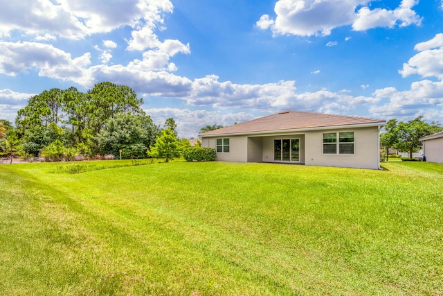 2571 SW Berry Park Cir, Palm City, FL 34990 - rear view of property featuring stucco siding, a yard, and a tiled roof