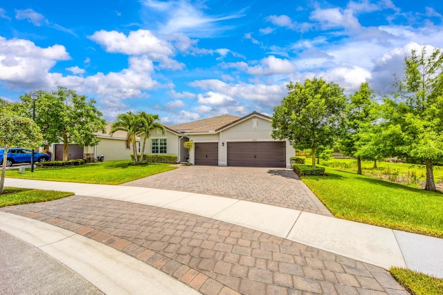 2571 SW Berry Park Cir, Palm City, FL 34990 - ranch-style home featuring decorative driveway, a garage, a front lawn, and stucco siding