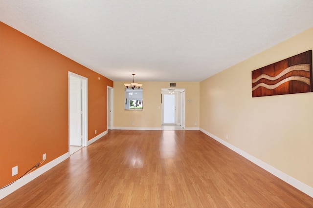 16 Willowbrook Ln Unit 102, Delray Beach, FL 33446 - unfurnished room featuring a chandelier and light wood-style floors