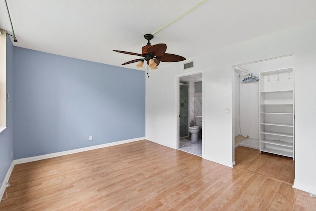 16 Willowbrook Ln Unit 102, Delray Beach, FL 33446 - unfurnished bedroom featuring wood finished floors, a spacious closet, a closet, ensuite bath, and ceiling fan