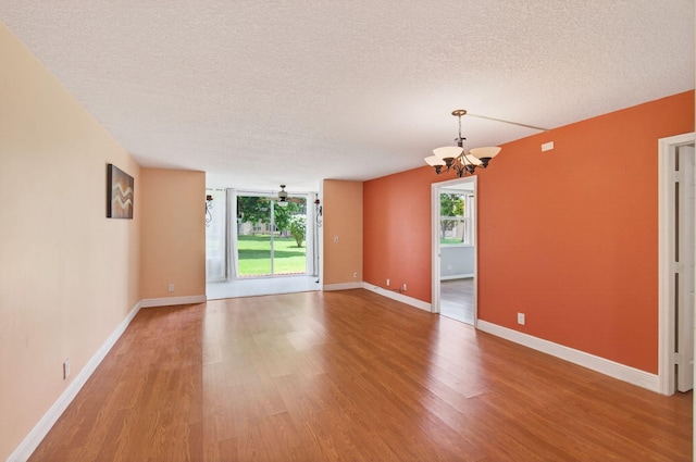 16 Willowbrook Ln Unit 102, Delray Beach, FL 33446 - empty room with a textured ceiling, a chandelier, and light wood-style floors