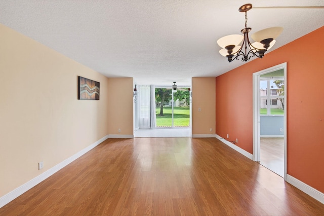 16 Willowbrook Ln Unit 102, Delray Beach, FL 33446 - empty room with a chandelier, light wood finished floors, and a textured ceiling