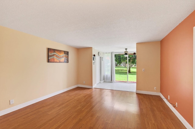 16 Willowbrook Ln Unit 102, Delray Beach, FL 33446 - empty room featuring wood finished floors, a ceiling fan, a textured ceiling, and a wall of windows