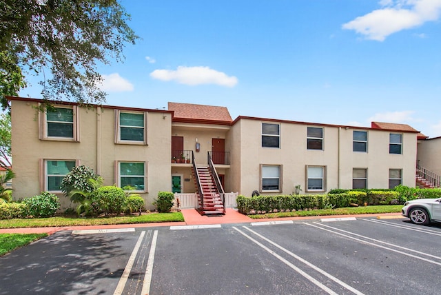 16 Willowbrook Ln Unit 102, Delray Beach, FL 33446 - view of property featuring stairs and uncovered parking