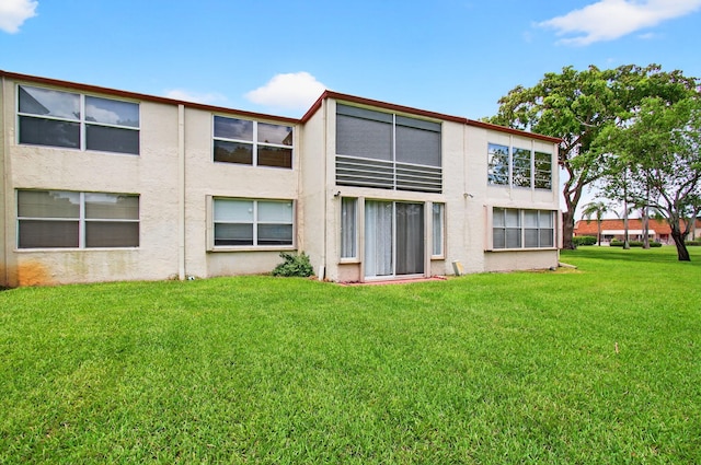 16 Willowbrook Ln Unit 102, Delray Beach, FL 33446 - rear view of property with stucco siding and a yard