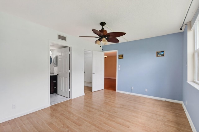 16 Willowbrook Ln Unit 102, Delray Beach, FL 33446 - unfurnished bedroom with wood finished floors, a spacious closet, ceiling fan, ensuite bath, and a closet