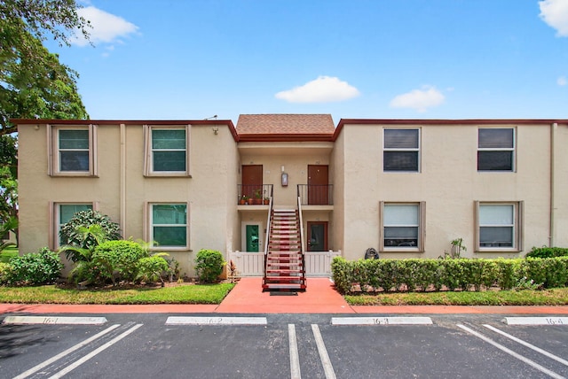 16 Willowbrook Ln Unit 102, Delray Beach, FL 33446 - view of building exterior with stairway and uncovered parking