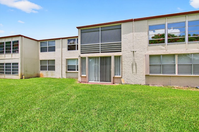 16 Willowbrook Ln Unit 102, Delray Beach, FL 33446 - rear view of house with stucco siding and a lawn