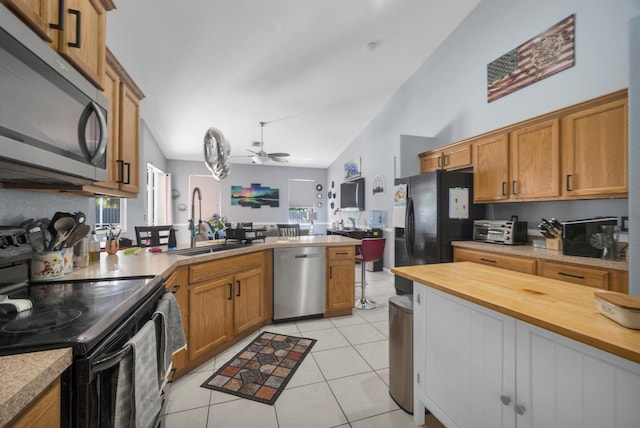 3982 SW Kabane St, Port Saint Lucie, FL 34953 - kitchen featuring stainless steel appliances, a peninsula, ceiling fan, light tile patterned floors, and brown cabinets