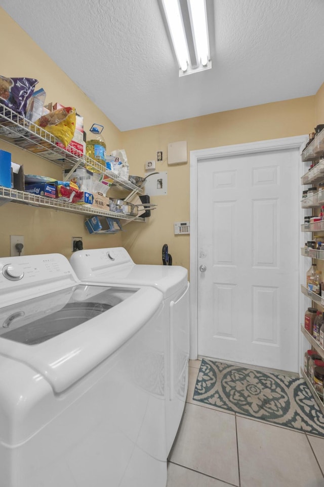 3982 SW Kabane St, Port Saint Lucie, FL 34953 - washroom featuring washing machine and clothes dryer, a textured ceiling, and light tile patterned floors