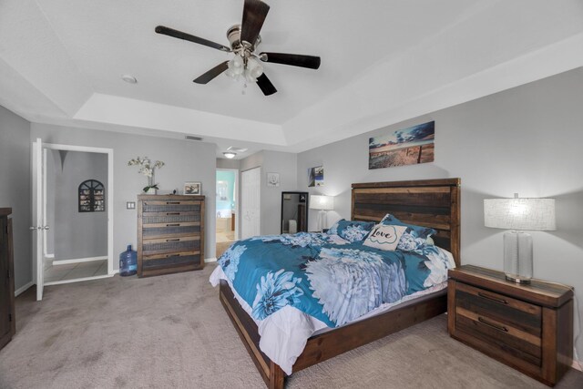 3982 SW Kabane St, Port Saint Lucie, FL 34953 - bedroom with a tray ceiling, carpet flooring, ensuite bath, and ceiling fan