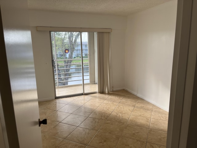 495 Fanshaw L Unit 495, Boca Raton, FL 33434 - tiled spare room featuring a textured ceiling and baseboards