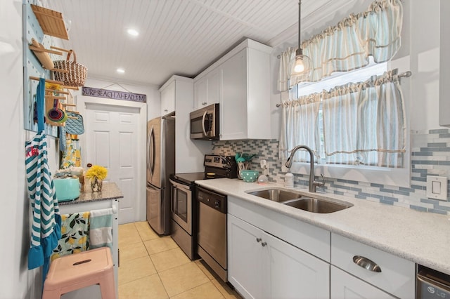 406 N D St, Lake Worth Beach, FL 33460 - kitchen with stainless steel appliances, white cabinetry, decorative backsplash, light tile patterned floors, and recessed lighting