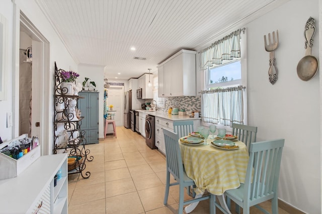 406 N D St, Lake Worth Beach, FL 33460 - kitchen featuring light countertops, white cabinets, decorative backsplash, stainless steel appliances, and ornamental molding