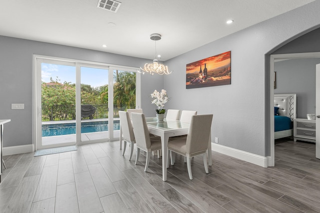 5783 NW 48th Ct, Coral Springs, FL 33067 - dining space featuring wood finished floors, arched walkways, recessed lighting, and a chandelier