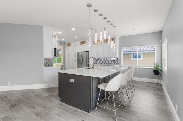 5783 NW 48th Ct, Coral Springs, FL 33067 - kitchen with stainless steel appliances, white cabinets, a large island, recessed lighting, and light stone counters