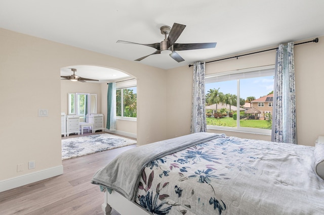 5783 NW 48th Ct, Coral Springs, FL 33067 - bedroom featuring wood finished floors, arched walkways, and a ceiling fan