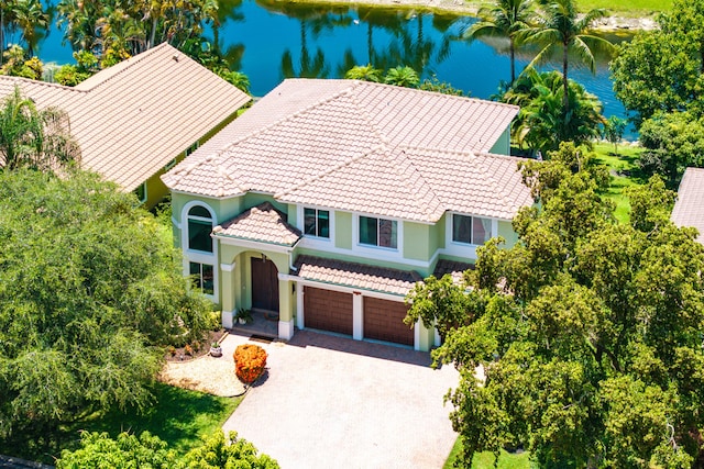 5783 NW 48th Ct, Coral Springs, FL 33067 - view of front facade featuring a tile roof, an attached garage, a water view, driveway, and stucco siding