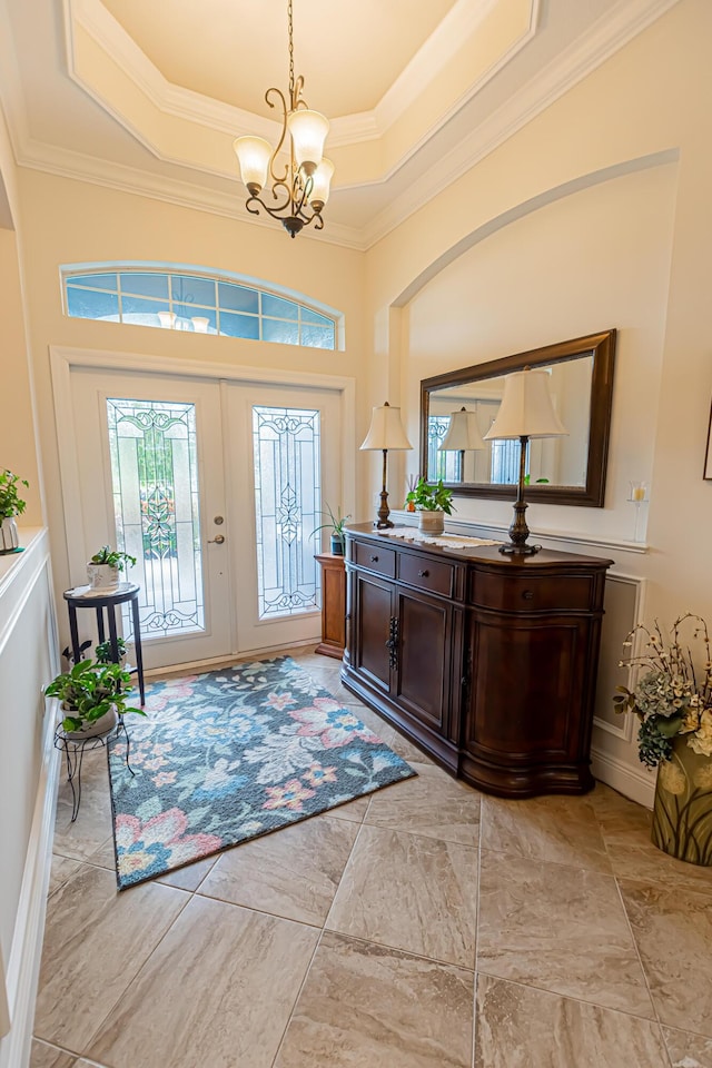 5927 NW Favian Ave, Port Saint Lucie, FL 34986 - entrance foyer with a chandelier, a tray ceiling, ornamental molding, and arched walkways