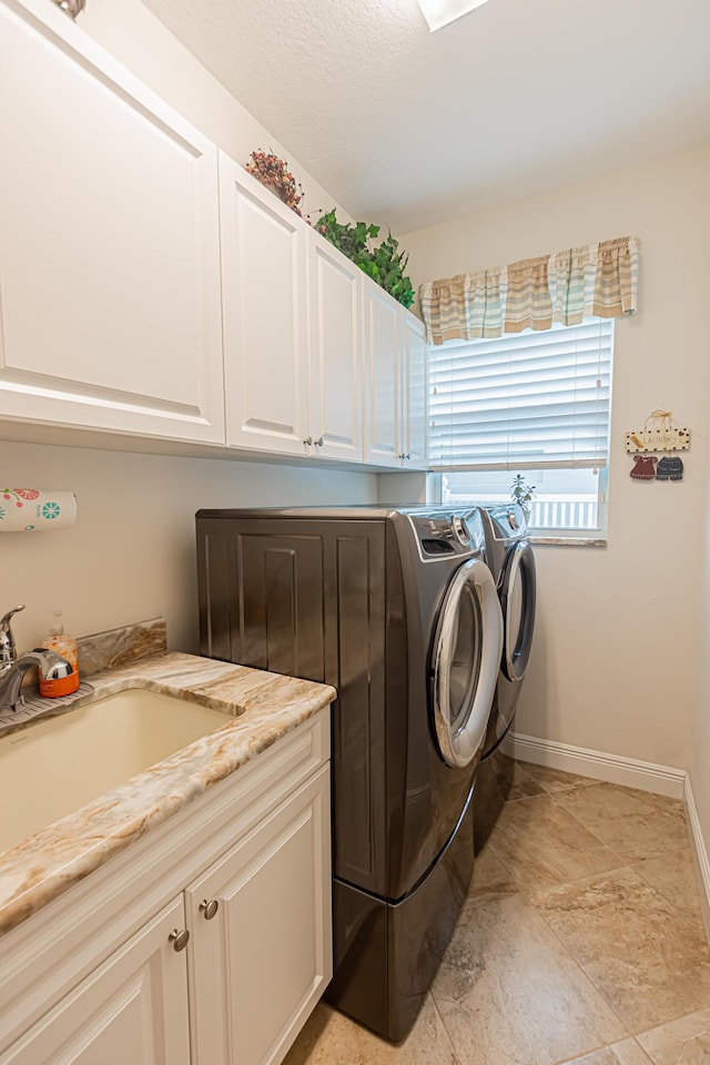 5927 NW Favian Ave, Port Saint Lucie, FL 34986 - laundry area with washer and dryer, cabinet space, and light stone finish flooring