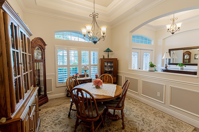 5927 NW Favian Ave, Port Saint Lucie, FL 34986 - dining area with a chandelier, crown molding, a decorative wall, a wainscoted wall, and arched walkways