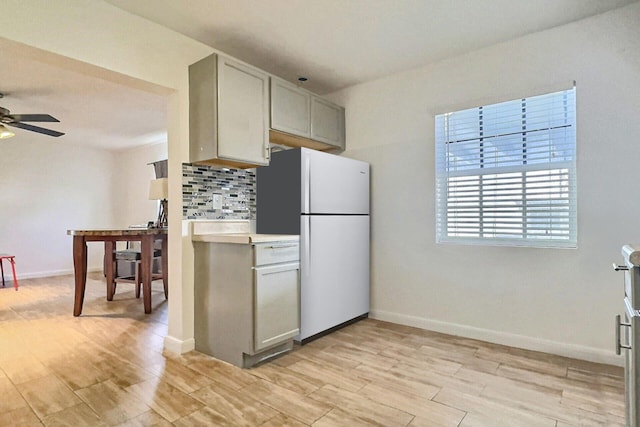 1206 Crestwood Blvd, Lake Worth, FL 33460 - kitchen featuring freestanding refrigerator, a ceiling fan, decorative backsplash, light wood-style flooring, and light countertops
