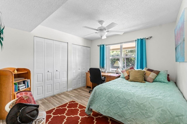 1124 NW 13th St Unit 204A, Boca Raton, FL 33486 - bedroom featuring light wood-style floors, a textured ceiling, two closets, a desk, and ceiling fan