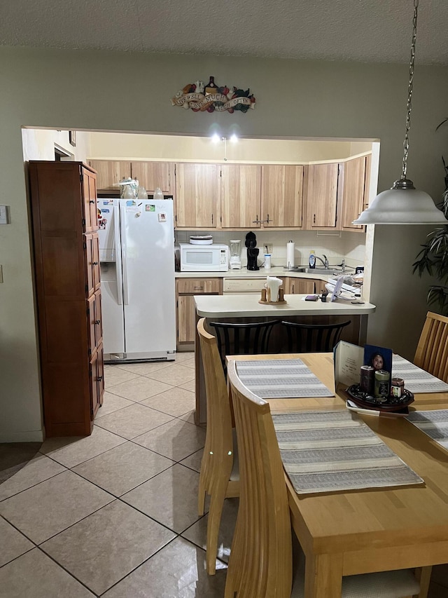 3623 La Playas Ct Unit A-1, Greenacres, FL 33463 - kitchen featuring white appliances, light countertops, pendant lighting, light tile patterned flooring, and a textured ceiling