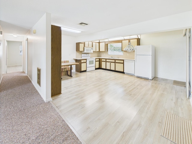 810 SE 13th St, Okeechobee, FL 34974 - kitchen featuring white appliances, light countertops, light wood-type flooring, and light brown cabinets