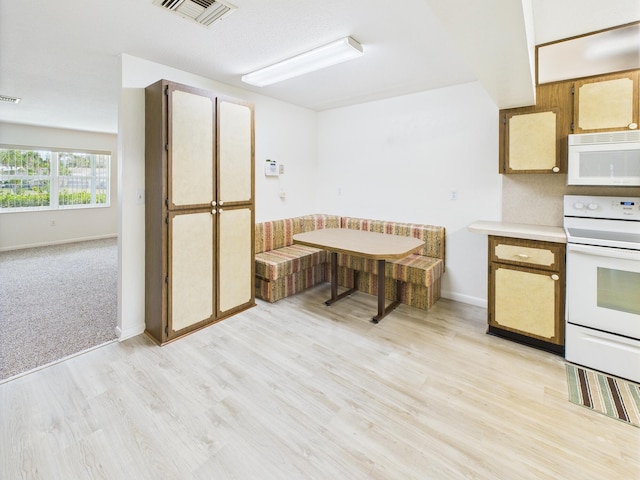 810 SE 13th St, Okeechobee, FL 34974 - kitchen featuring white appliances, light wood-style flooring, and light countertops