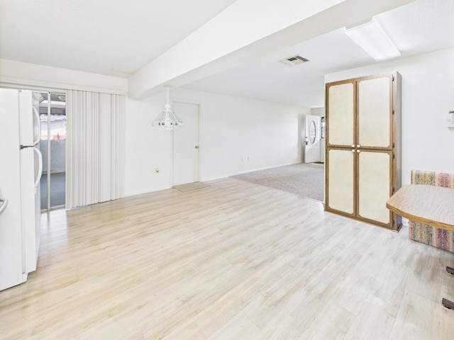 810 SE 13th St, Okeechobee, FL 34974 - unfurnished room with light wood-style flooring and stacked washer / dryer