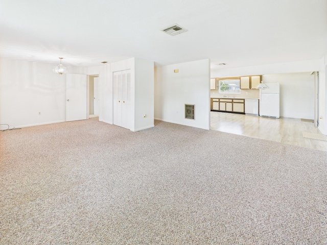 810 SE 13th St, Okeechobee, FL 34974 - unfurnished living room featuring a chandelier and carpet