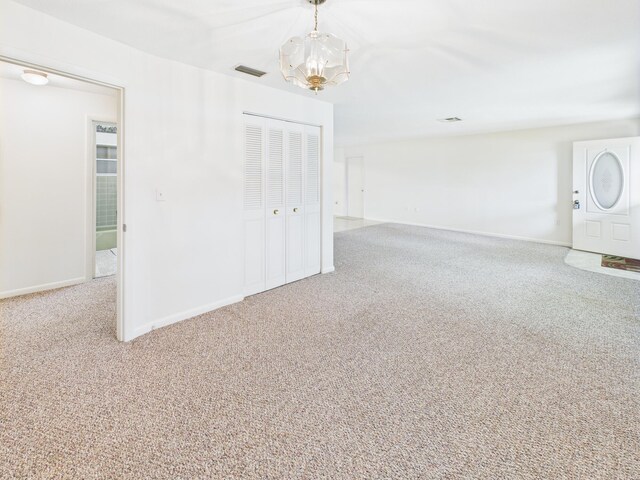810 SE 13th St, Okeechobee, FL 34974 - spare room featuring a chandelier and carpet flooring