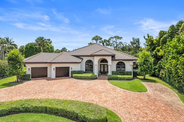 1257 Breakers W Blvd, West Palm Beach, FL 33411 - mediterranean / spanish-style home featuring french doors, a chimney, an attached garage, and stucco siding