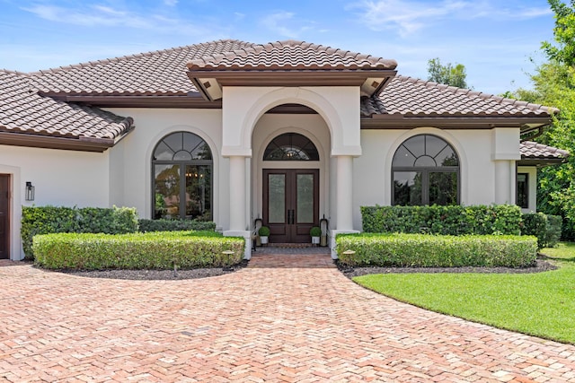 1257 Breakers W Blvd, West Palm Beach, FL 33411 - property entrance with french doors, a tiled roof, and stucco siding