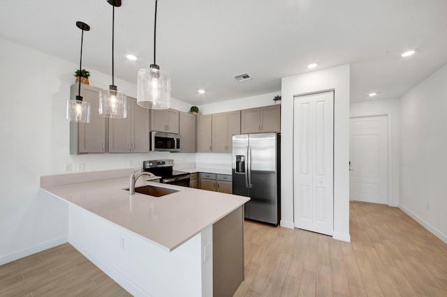 14511 Three Ponds Trl, Delray Beach, FL 33446 - kitchen featuring appliances with stainless steel finishes, light wood-type flooring, a peninsula, light countertops, and pendant lighting