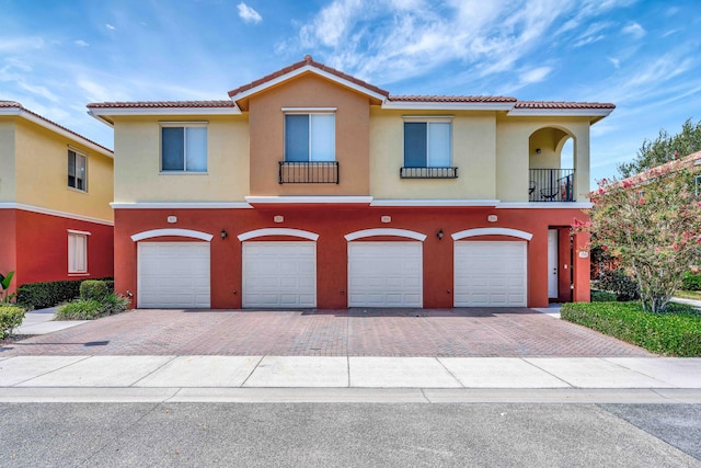 40 SE Sedona Cir Unit 104, Stuart, FL 34994 - view of front of home with driveway, an attached garage, stucco siding, and a tile roof