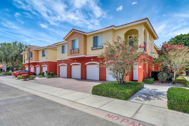 40 SE Sedona Cir Unit 104, Stuart, FL 34994 - mediterranean / spanish-style home featuring a garage, driveway, stucco siding, and a tiled roof