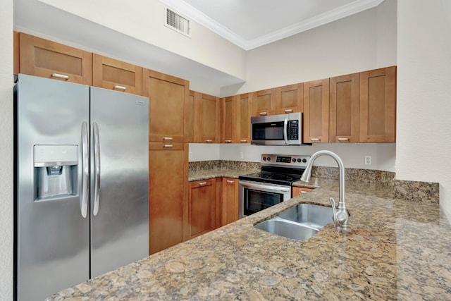40 SE Sedona Cir Unit 104, Stuart, FL 34994 - kitchen with stainless steel appliances, crown molding, light stone countertops, and brown cabinets